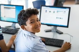 Kid studying coding on a computer in a classroom